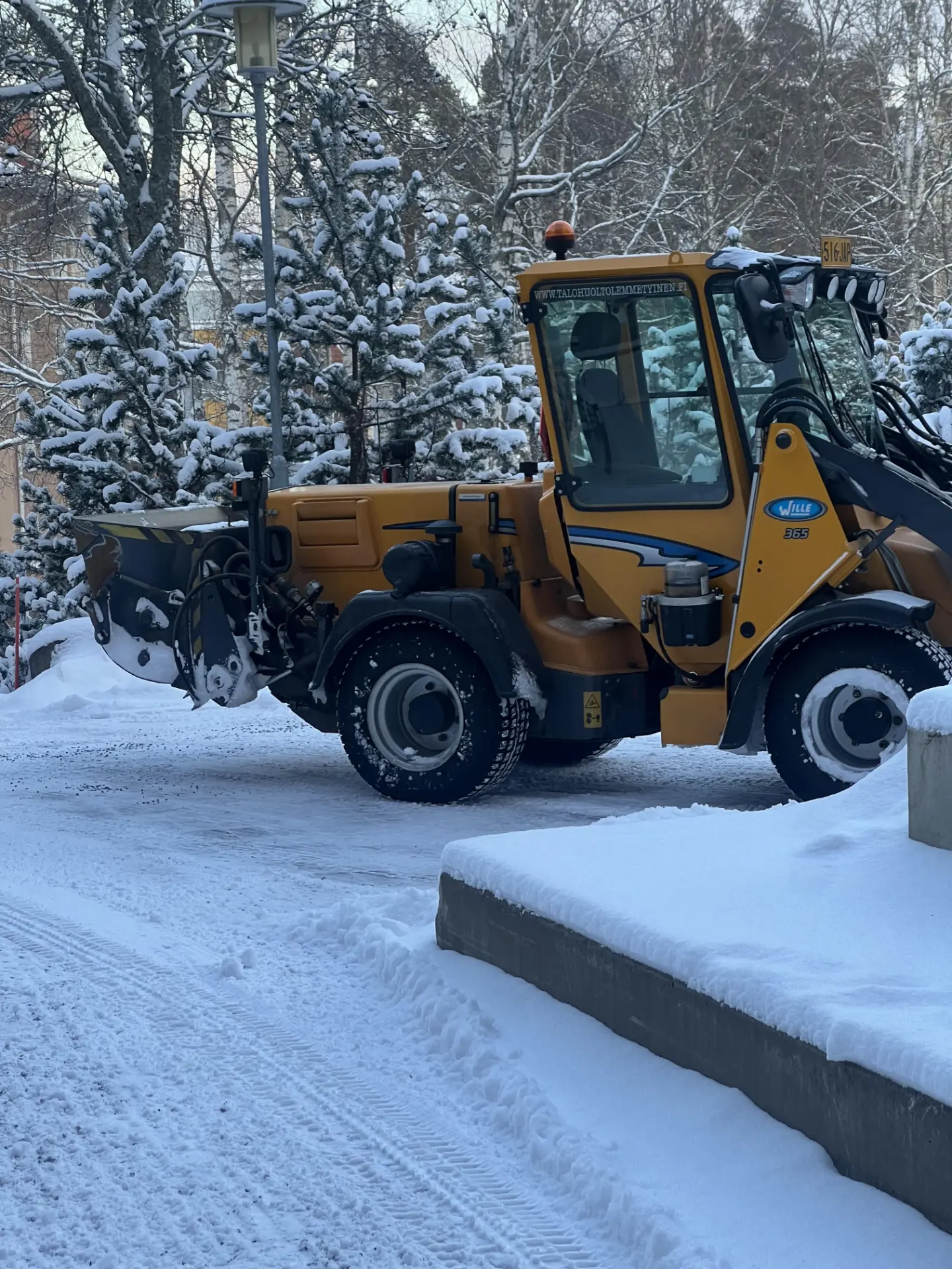 Joen Talohuollon pihakone auralla lumitöissä